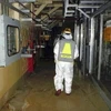 Tác nghiệp viên đi qua tầng 1 lò 2 Nhà máy điện hạt nhân Fukushima 1. (Nguồn: Yomiuri Shimbun) 