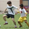 Park Ji-Sung hướng dẫn trẻ em Việt Nam chơi bóng. (Ảnh: Quang Nhựt/TTXVN)
