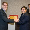 Đại sứ Hoàng Vĩnh Thành (phải) trao tặng Kỷ niệm chương cho giáo sư Ian Young. (Ảnh: Quang Minh/Vietnam+)