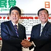 Cựu Thủ tướng Shinzo Abe (trái) và Tổng thư ký Shigeru Ishiba trong buổi niêm yết tên cử tri trong cuộc bầu cử Hạ viện ở Tokyo ngày 16/12. (Ảnh: AFP)
