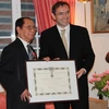 Đại sứ Pháp tại Việt Nam Poirier đã trao Huân chương cho ông Trịnh Ngọc Thái. (Ảnh: PV/Vietnam+)