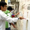 Thanh niên tình nguyện phường Liễu Gia, quận Ba Đình xóa bỏ quảng cáo rao vặt. (Ảnh: Đình Trân/TTXVN) 