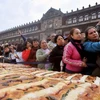 Người dân tập trung đợi được phân phát bánh truyền thống "Rosca de Reyes". (AFP- TTXVN)