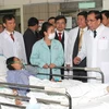 Tổng Bí thư Nông Đức Mạnh thăm bệnh nhân đang điều trị tại bệnh viện. (Ảnh: Đinh Xuân Tuân/TTXVN) 