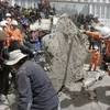 Các nhân viên cứu hộ nỗ lực tìm cứu các nạn nhân bị chôn vùi trong đống đổ nát. (Ảnh: THX/TTXVN) 