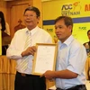 Ông Đoàn Kim Phách, Phó Chủ tịch Liên đoàn Xe đạp – Mô tô thể thao Việt Nam trao quyết định tổ chức giải cho đại diên Công ty ADC. (Ảnh: Hồ Dung/Vietnam+)