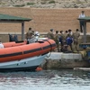 Đưa thi thể nạn nhân của vụ lật tầu vừa được tìm thấy lên bờ. (Nguồn: AFP/TTXVN)