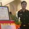 Anh Võ Văn Cương bên cạnh tác phẩm đạt Giải Đặc biệt của đơn vị. (Ảnh: Hồng Kiều/Vietnam+)