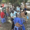 Các tình nguyện viên đang cắt toc cho bệnh nhân tâm thần tại Trại điều dưỡng tâm thần Hà Nội. (Ảnh: Hồng Kiều/vietnam+)