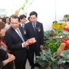 Phó Thủ tướng Vũ Văn Ninh và Bộ trưởng Bộ Nông nghiệp và Phát triển nông thôn Cao Đức Phát tham quan hội chợ. (Ảnh: Hồng Kiều/Vietnam+)
