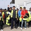 Những người lao động Việt Nam từ Libya phấn khởi về đến sân bay Nội Bài an toàn. (Ảnh: Hữu Việt/TTXVN)