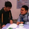 Người khuyết tật đang phỏng vấn xin việc tại ngày hội. (Ảnh: Hồng Kiều/Vietnam+)