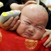 Một cháu bé Trung Quốc đang được cắt tóc để lấy may trong ngày 2/2 Âm lịch. (Ảnh: Chinadaily)