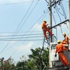 Công nhân ngành điện đang cải tạo hệ thống cấp điện tại khu dân cư. (Ảnh: Quách Lắm/TTXVN)