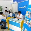 Nhân viên VinaPhone hướng dẫn khách hàng sử dụng dịch vụ 3G. (Ảnh: Trần Thanh Giang/TTXVN)