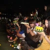 Người dân tham gia lễ hội Loy Krathong, thắp hương nến và thả đèn hoa đăng xuống nước ở một công viên tại trung tâm Bangkok. (Ảnh: Ngọc Tiến/Bangkok)