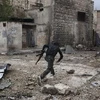 Binh sỹ lực lượng nổi dậy chạy tránh đạn trong cuộc xung đột ở quận Karm al-Jabal, thành phố Aleppo ngày 22/10 vừa qua. (Ảnh: AFP/TTXVN)