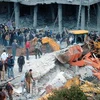 Dọn đống đổ nát của tòa nhà bị phá hủy trong cuộc giao tranh tại thành phố al-Arman ngày 9/12 vừa qua. (Ảnh: AFP/TTXVN)