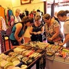 Du khách nước ngoài mua hàng lưu niệm tại Festival Huế 2012. (Ảnh: Thanh Hà/TTXVN)