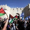 Người dân Palestine và Israel vẫy cờ bên ngoài cổng Damascus hôm 8/5. (Nguồn: AFP)