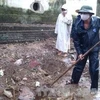 Người dân đào tìm hóa chất được chôn xuống đất (Nguồn: TTXVN)