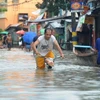Cảnh ngập lụt trên đường phố ở ngoại ô Manila, ngày 3/10. (Ảnh: AFP/TTXVN)