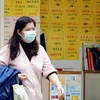 Người dân đeo khẩu trang phòng cúm đi lại trên một đường phố ở Hongkong. (Ảnh: AFP/TTXVN) 