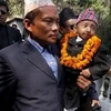 Khagendra Thapa Magar, được bố bế đi gặp gỡ giới báo chí trước lúc rời Nepal đến châu Âu. (Ảnh: AP)