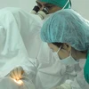 Các bác sĩ tiến hành phẫu thuật đục thủy tinh thể cho bệnh nhân. (Ảnh: Thanh Vũ/TTXVN) 