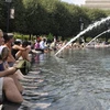 Người dân tránh nóng tại đài phun nước ở Washington D.C. (Nguồn: THX/TTXVN)