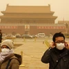 Những khách du lịch người Trung Quốc đeo khẩu trang để chụp ảnh tại Quảng trường Thiên An Môn trong đợt bão cát lớn hồi tháng Ba năm ngoái. (Nguồn: Reuters)