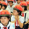 Trao mũ bảo hiểm cho học sinh tiểu học. (Ảnh minh họa: Thanh Tùng/TTXVN)