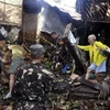 Binh sĩ Philippines cứu hộ người dân còn mắc kẹt trong đống đổ nát sau vụ lũ quét. (Nguồn: AP) 
