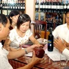 Kiểm tra nhãn mác rượu và phát hiện rượu giả ở một nhà hàng ăn. (Ảnh: Hữu Oai/TTXVN)