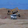Máy xúc quặng bauxite lên một xe tải tại mỏ của Tập đoàn Khoáng sản Trung Quốc Bosai. (Nguồn: Reuters)