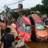 Dọn những chiếc xe đổ sau mưa lớn ở Bắc Kinh ngày 23/7. (Nguồn: AFP/TTXVN)