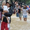 Người dân sơ tán khỏi vùng ngập lụt ở ngoại ô Manila ngày 9/8. (Nguồn: AFP/TTXVN)
