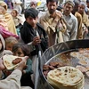 Người dân xếp hàng để nhận thức ăn miễn phí của một nhà hàng tại thành phố Rawalpindi, Pakistan. (Nguồn: guardian.co.uk)