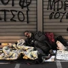 Người không nhà ở ngủ bên ngoài một ngân hàng ở trung tâm thủ đô Athens. (Nguồn: AFP/TTXVN)