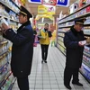 Cán bộ quản lý thị trường Trung Quốc kiểm tra sữa bột bày bán tại siêu thị. (Nguồn: AP)