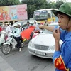 Thanh niên tình nguyện tham gia giữ trật tự an toàn giao thông (Ảnh: Thế Duyệt/TTXVN)