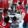 Các tình nguyện viên của Hội Chữ thập đỏ Việt Nam đang phân loại, đóng gói quần áo ủng hộ nhân dân miền Trung. (Ảnh: Thanh Tùng/TTXVN)