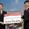 Trao tượng trưng số tiền ủng hộ đồng bào miền Trung qua Cổng thông tin điện tử nhân đạo quốc gia cho Hội Chữ thập Đỏ Việt Nam. (Ảnh: Thanh Tùng/TTXVN)