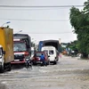 Nước lũ tràn qua Quốc lộ 1A. (Ảnh: Trần Tính/TTXVN)