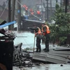 Nhân viên cứu hộ tìm cứu nạn nhân lũ lụt do bão Utor. (Nguồn: AFP/TTXVN)