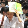 Thí sinh điểm thi Trường Trung học phổ thông Việt Đức ngồi nghe quy chế dưới trời nắng gay gắt. (Ảnh: Phạm Mai/Vietnam+).