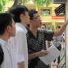Thí sinh điểm thi Trường Trung học phổ thông Việt Đức dò tìm số báo danh. (Ảnh: Phạm Mai/Vietnam+).
