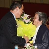 Phó Thủ tướng Nguyễn Thiện Nhân tặng hoa cụ bà Hoàng Kim Anh, vợ cố Giáo sư Tạ Quang Bửu. (Ảnh: Phạm Mai/Vietnam+).