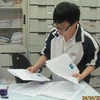 Học sinh phân loại hồ sơ dự thi đại học tại trường Trung học phổ thông Trần Phú, Hà Nội. (Ảnh: Phạm Mai/Vietnam+)