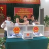 Cô giáo Ngân (thứ hai từ phải sang) cùng người dân xã Thanh Liệt hồ hởi bỏ phiếu bầu cử. (Ảnh: Thiên Linh/Vietnam+)
